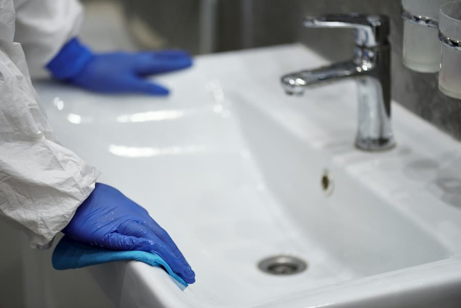 Technician with blue gloves performing plumbing repair on sink