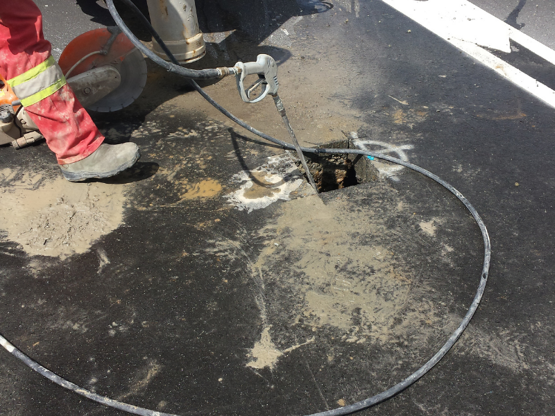 Technician using a hydro jetting hose to clear sewer line