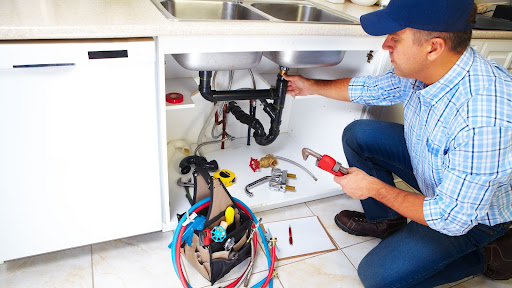 Master plumber fixing sink